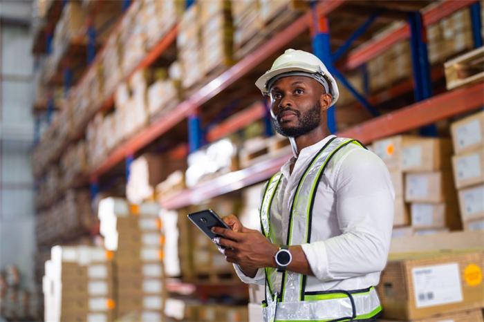 Warehouse worker checking wholesale delivery details before cigarette dispatch